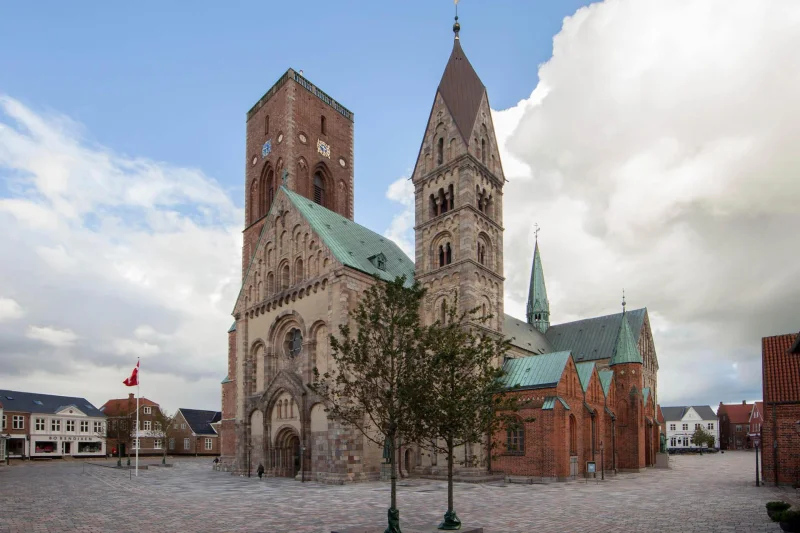 Domkirken set udefra. Lidt blå himmel og tunge hvide skyer.